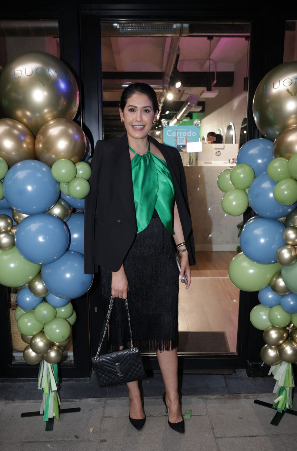 la ex de bertin osborne con falda y americana negra y top verde en su centro de estetica
