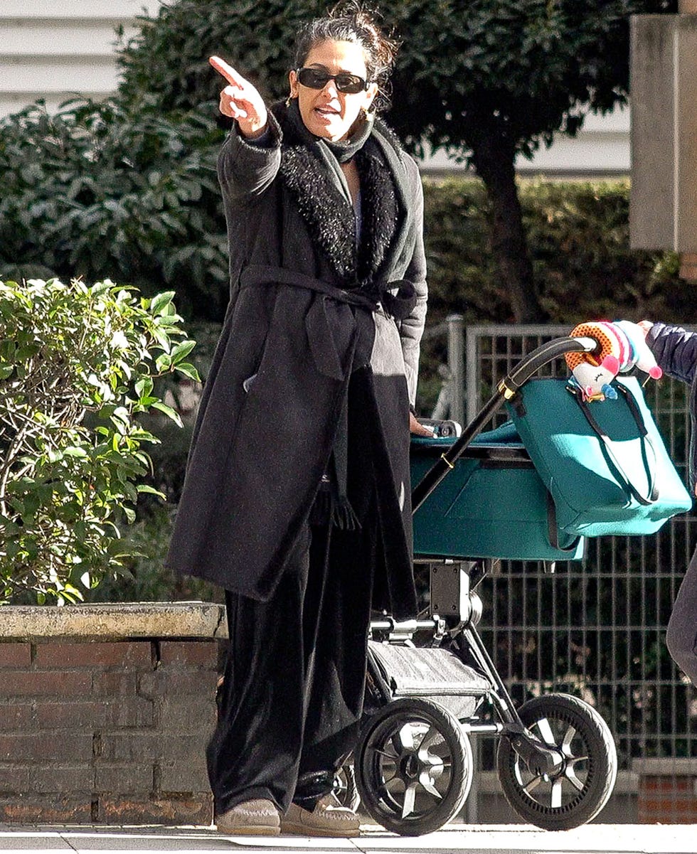 a person in a black robe and sunglasses holding a cell phone