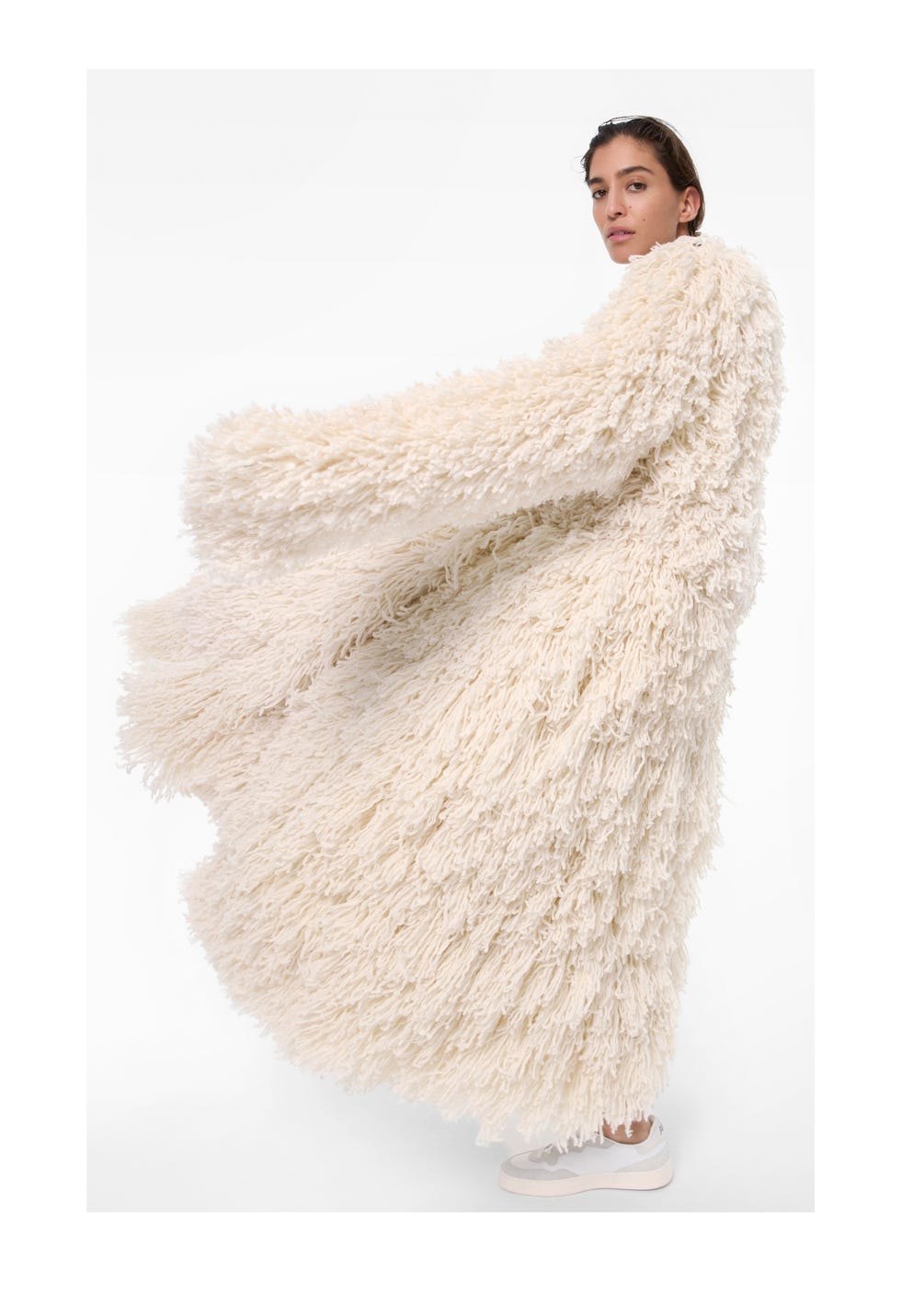 model wearing a fluffy long coat and light sneakers