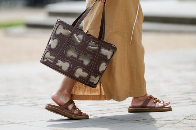 mujer con vestido, bolso marron y sandalias