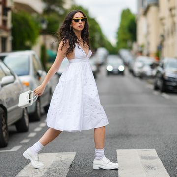 een vrouw op straat in een witte jurk