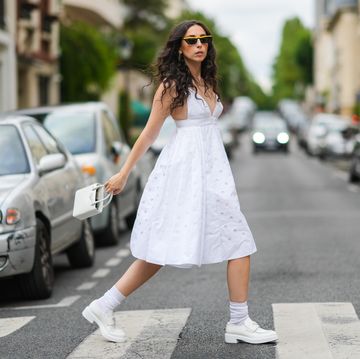 een vrouw op straat in een witte jurk