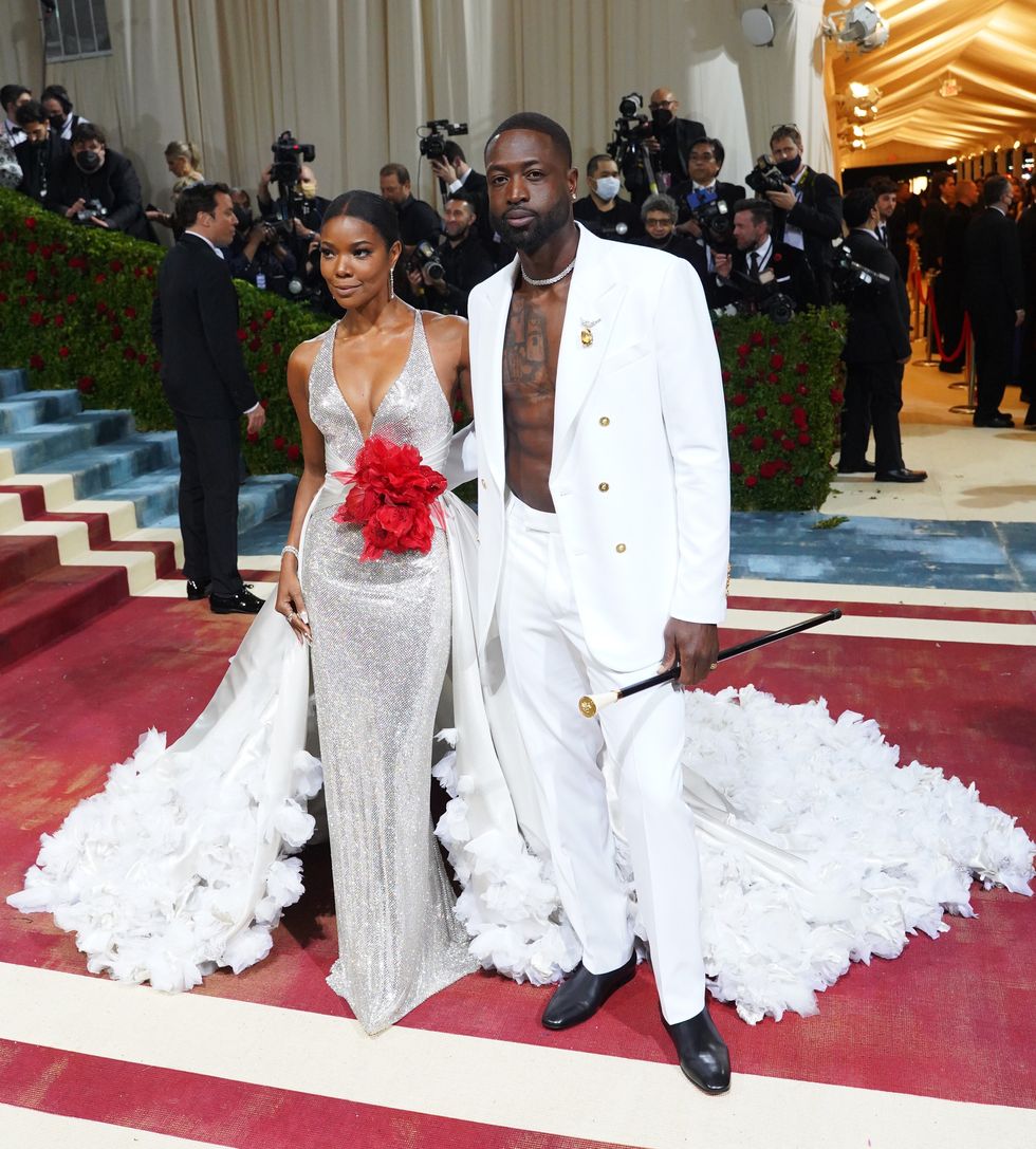 gabrielle union and dwayne wade posing for a photo in all white and silver versace at the 2022 costume institute benefit in america an anthology of fashion