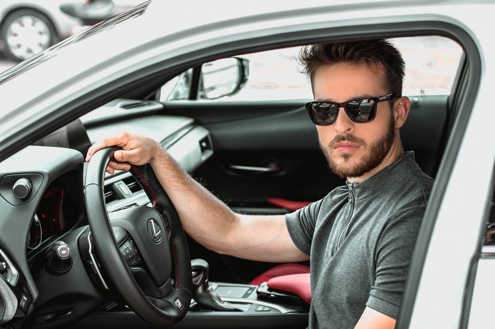 a man wearing sunglasses and sitting in a car
