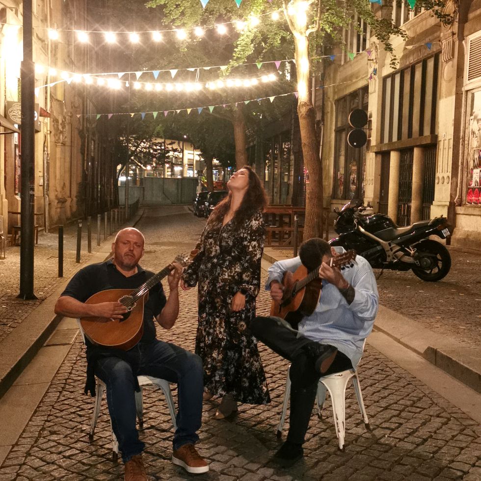 performers singing outside a bar on the street