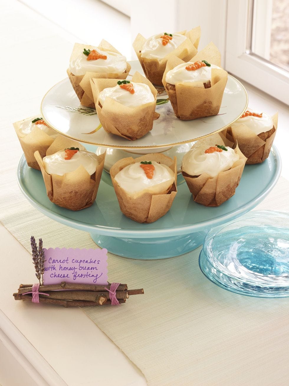 carrot cupcakes with honey cream cheese served on a cake plater
