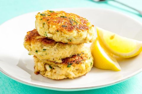 crab cakes stacked with some lemon wedges on the side