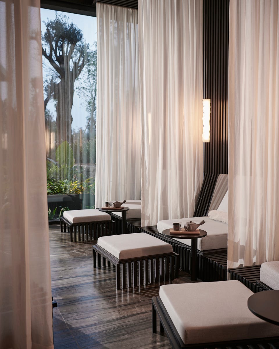 a room with a wood floor and white curtains