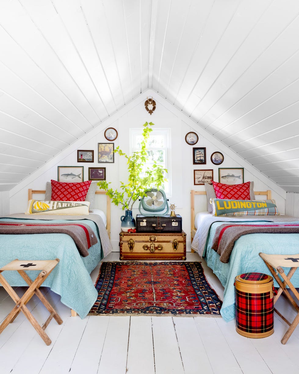 attic bedroom with twin beds and suitcases stacked as the table