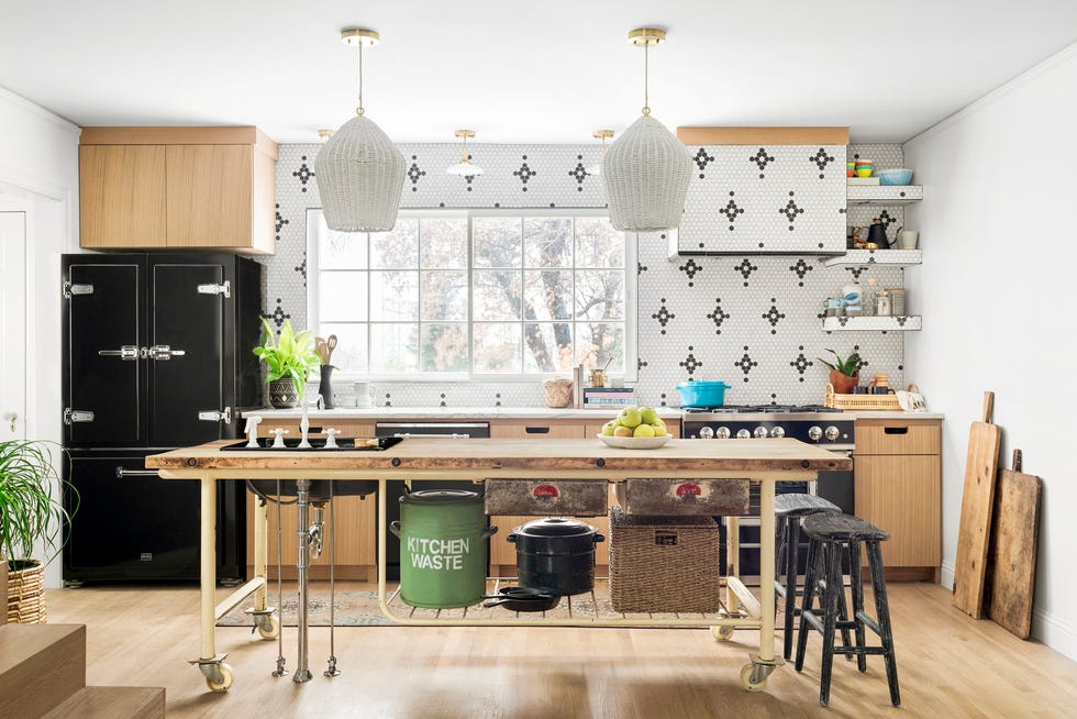 Galley kitchen with black and white tile backsplash and industrial table island