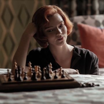una chica mira el tablero de ajedrez