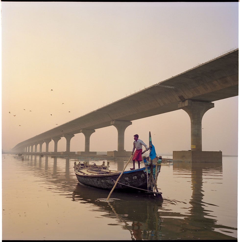 In Patna kijkt een schipper bij een nieuwe snelweg uit over de Ganges Door de snelle ontwikkeling van India is de vraag naar plastic sterk gestegen De plasticindustrie is er een van de grootste ter wereld