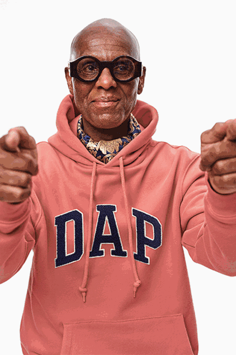 individual wearing a pink hoodie with dap printed on it extending hands forward