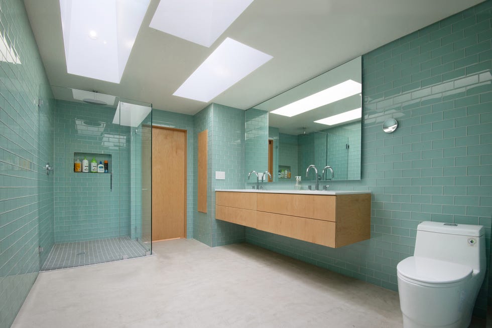 baño con ducha de obra y azulejos de color turquesa