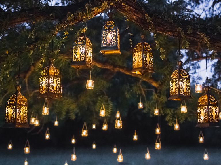 garden lighting ideas, hanging lanterns draping from tree branch