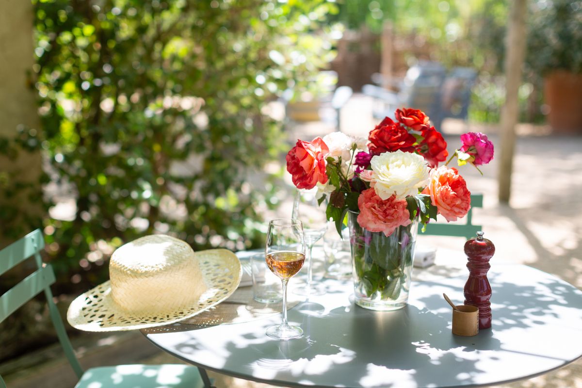 garden table set up with flowers and wine