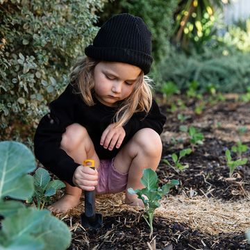 young kid digging in garden