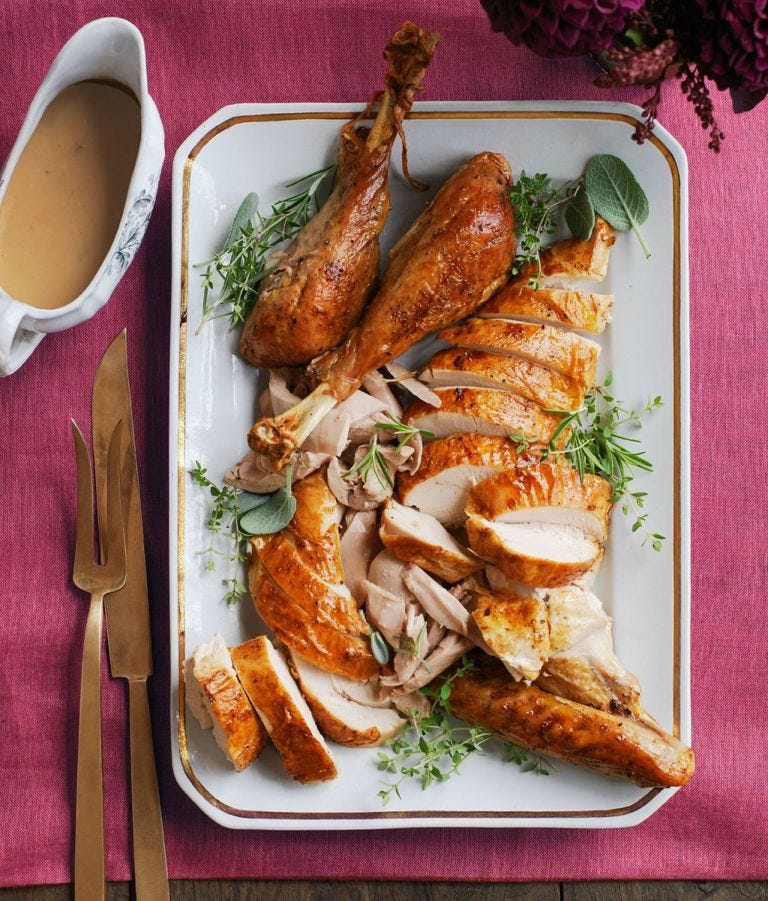 garlic and herb roasted turkey sliced on a white serving platter