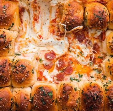 garlic bread lined in a baking dish with cheese and pepperoni dip in the middle