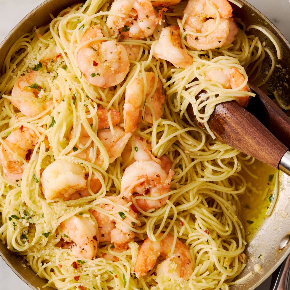 garlic butter shrimp pasta in a white bowl, topped with parmesan