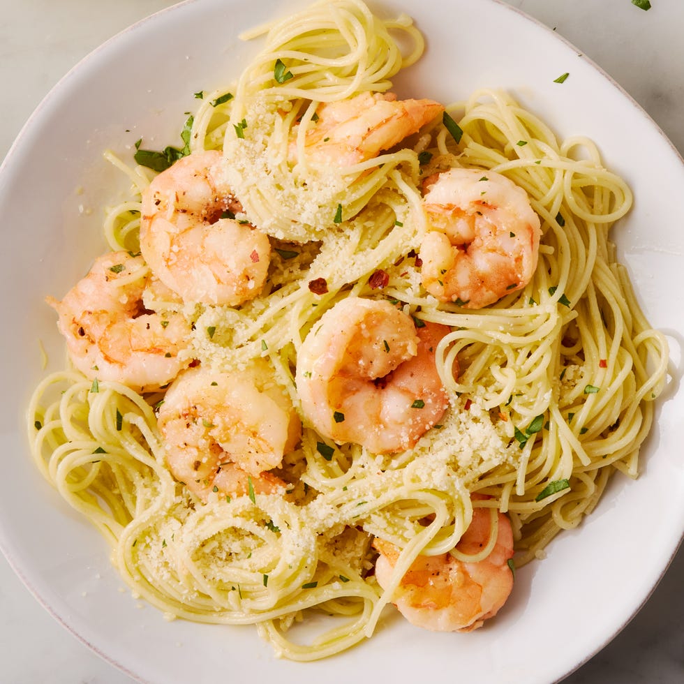 garlic butter shrimp pasta in a white bowl, topped with parmesan