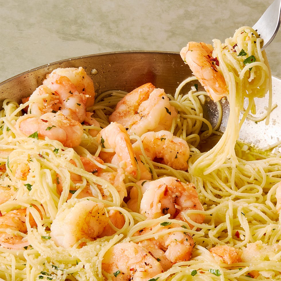 garlic butter shrimp pasta in a white bowl, topped with parmesan