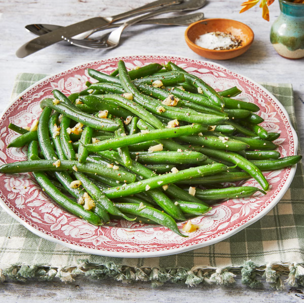 garlic green beans on a red decorated plate