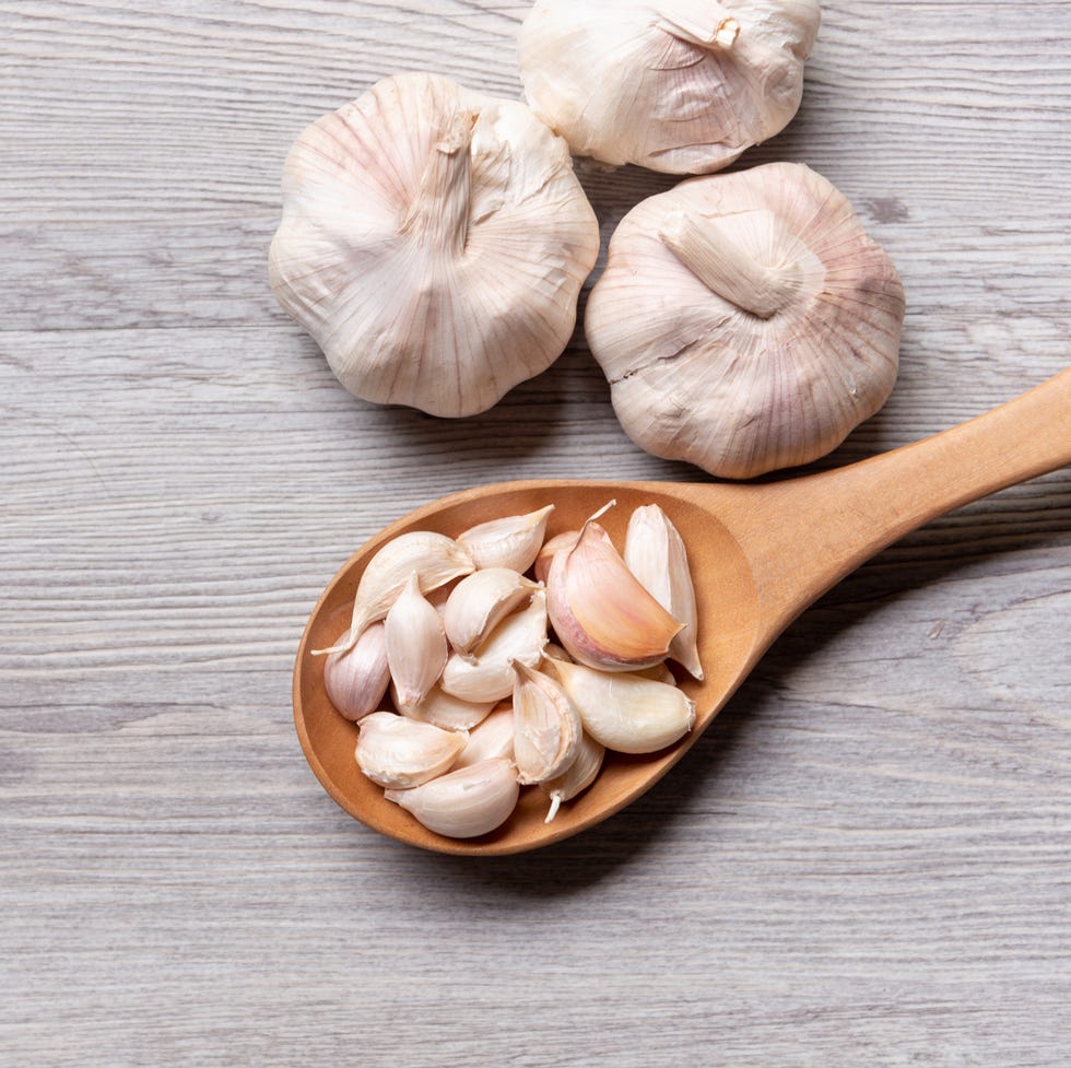 garlic in wooden spoon on table