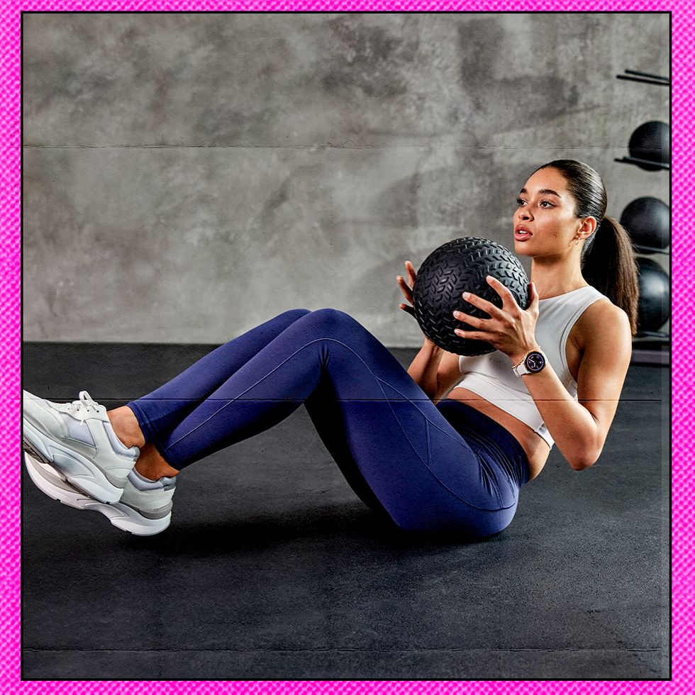 a person doing russian twists holding a gym ball
