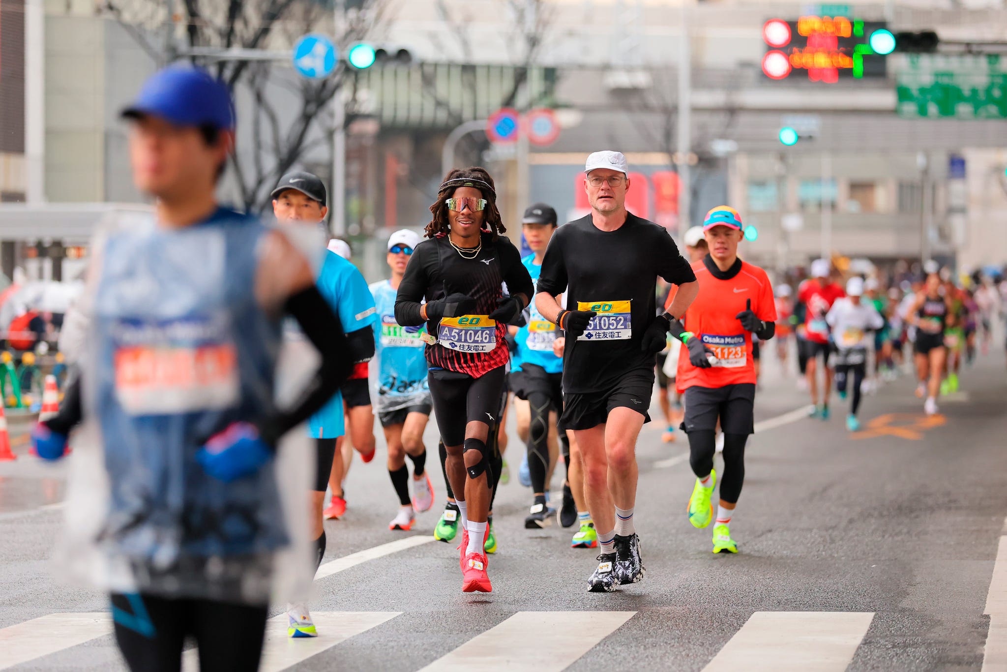 a group of people running marathon in tokyo