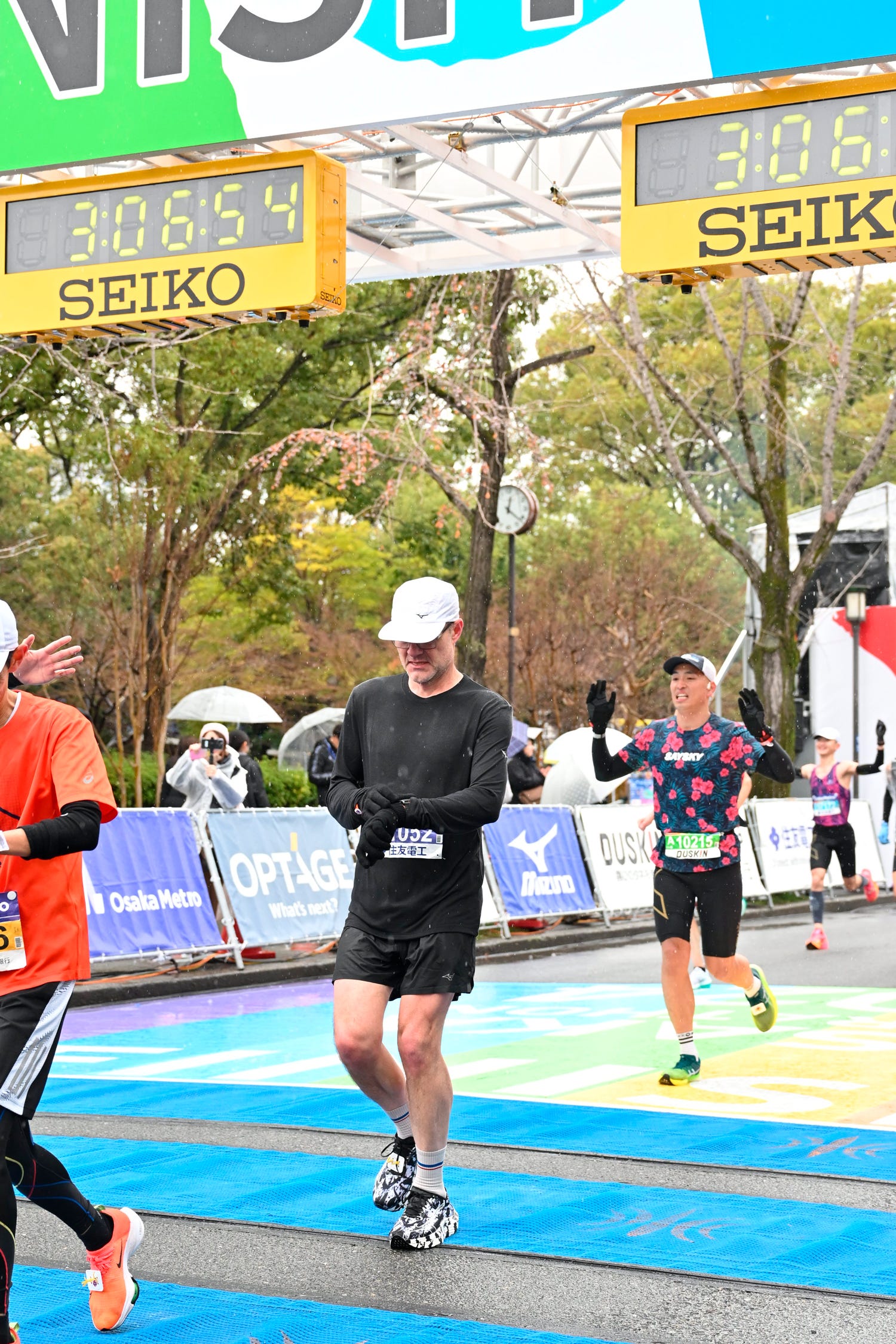 checking garmin smartwatch at finish line of tokyo marathon