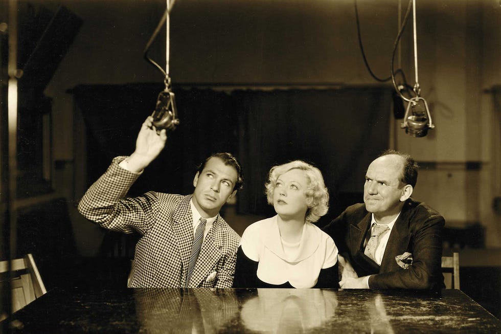 marion davies eyes the microphone before her radio debut with gary cooper and ted healy in a 1934 production of "operator 13"