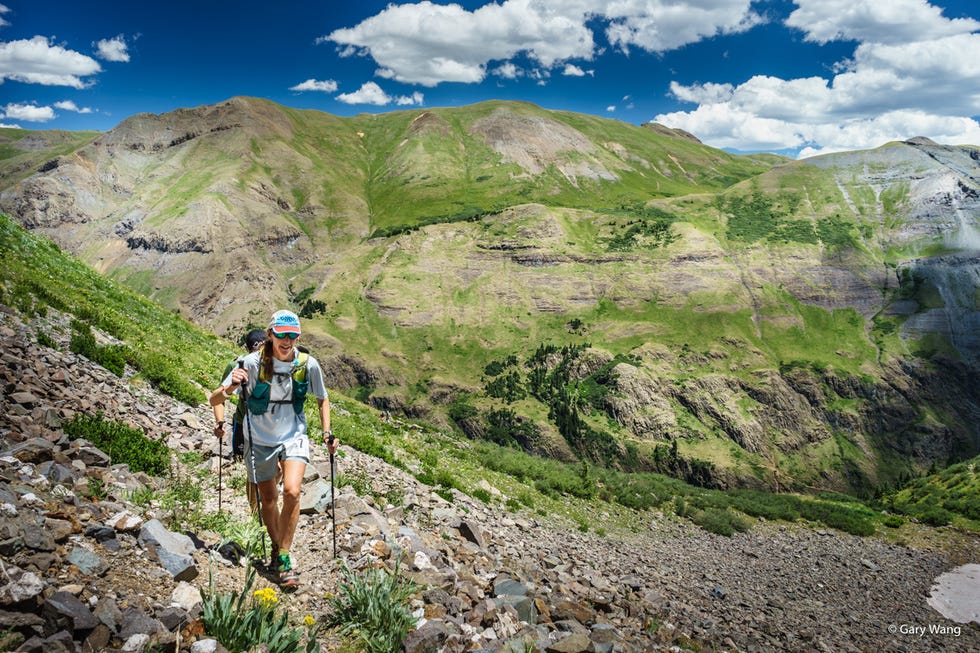 hiker ascending a mountainous terrain on a clear day hurt 100 trail run