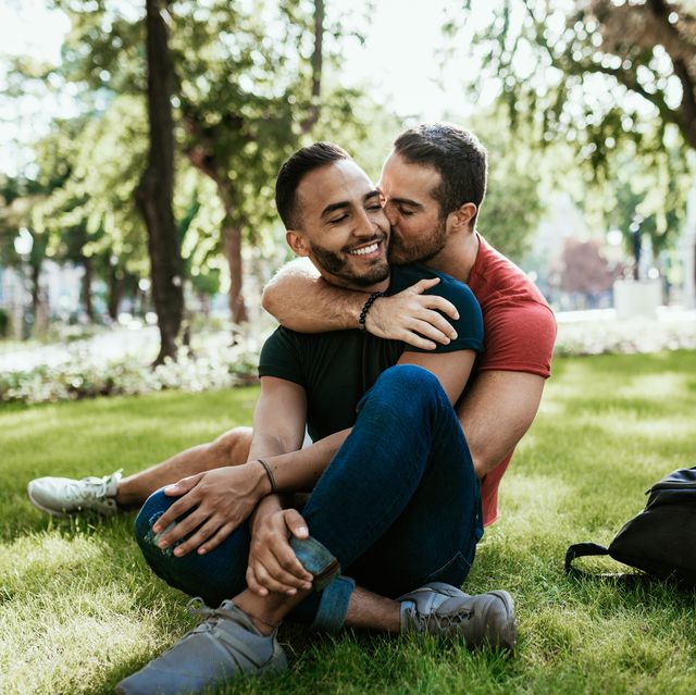 gay couple latino and european millennial men  enjoying in park in summer