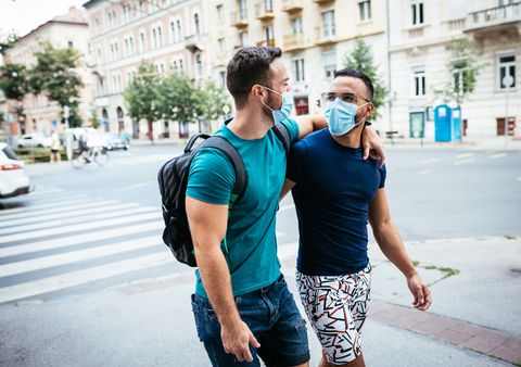 gay couple traveling together and wearing face masks