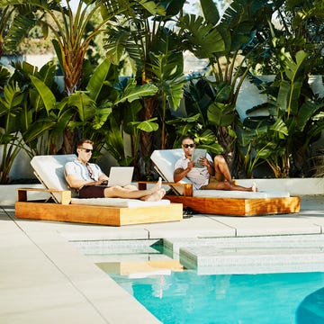 mannen bij het zwembad op luxe tuinstoelen