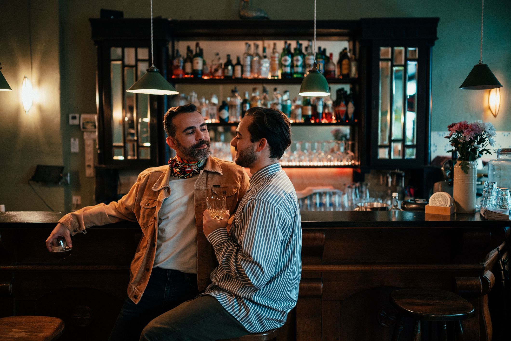 gay male couple sitting at a bar