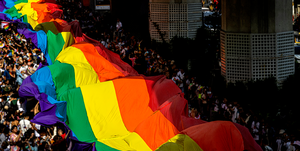 a crowd of people holding lgbtq pride flags