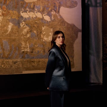 a figure stands in front of a historical mural backdrop a figure stands in front of a historical mural backdrop