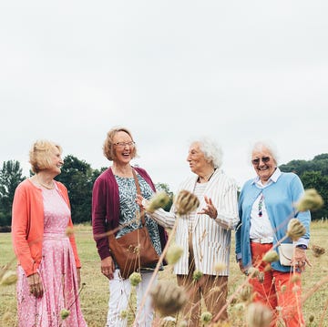 group of four older women laughing in a wheat field group of four older women laughing in a wheat field