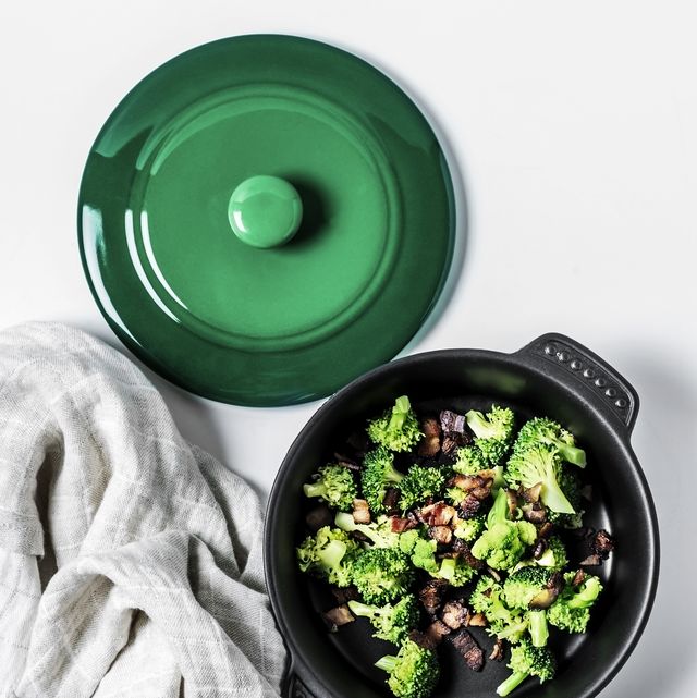 a bowl of broccoli salad with fried bacon on white background