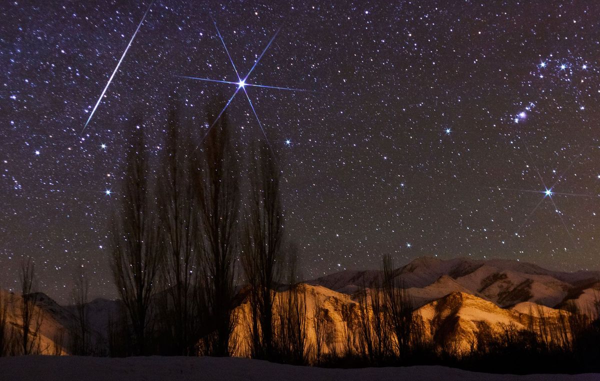 Een heldere meteoor schiet bij Sirius door de hemel tijdens het hoogtepunt van de meteorenzwerm Geminiden