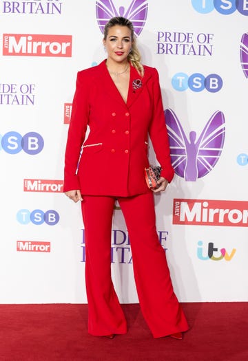 gemma atkinson wearing her hair up in a ponytail and a red suit