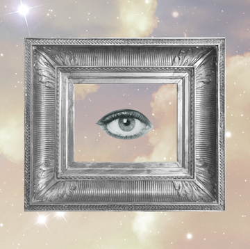 a single eye looks out at the viewer from within a silver picture frame over a cloudy, starry sky