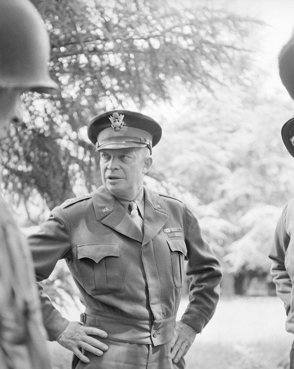 general dwight d eisenhower with his hands on his hips speaking to troops