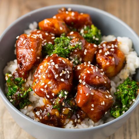 general tsos chicken with broccoli garnished with sesame seeds over white rice