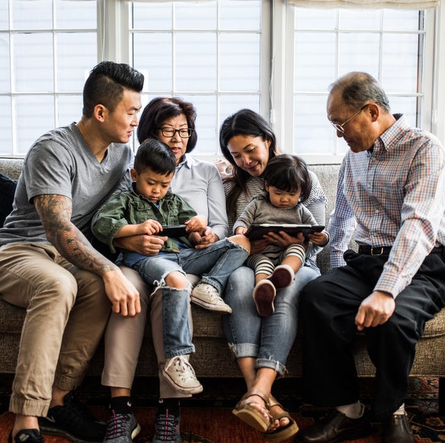 3 generations on couch looking at tablet 3 generations on couch looking at tablet