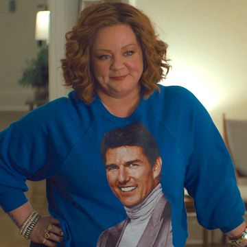 melissa mccarthy in genie, a woman smiles as she wears a blue jumper with tom cruise's face on it