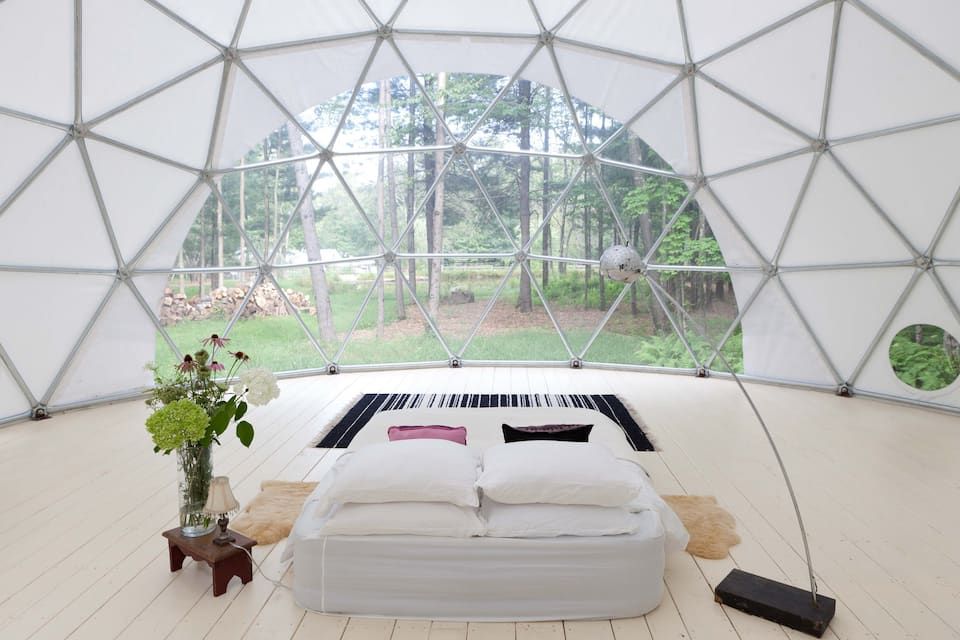 interior of geo dome with bed and lamp at center