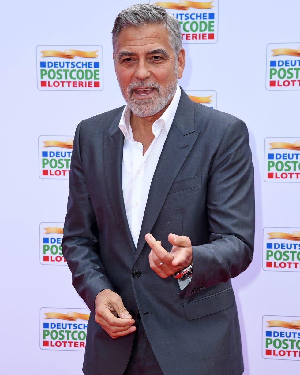 George Clooney attends the Postcode Lotterie Charity Gala In Düsseldorf george clooney talking to photographers off camera as he poses on the red carpet